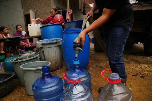 A resident fills their container with clean water as others wait for their turn from a tanker truck amid a drought in Sanggau, West Kalimantan, Indonesia, Friday, Sept. 11, 2026. (AP Photo/Tatan Syuflana)