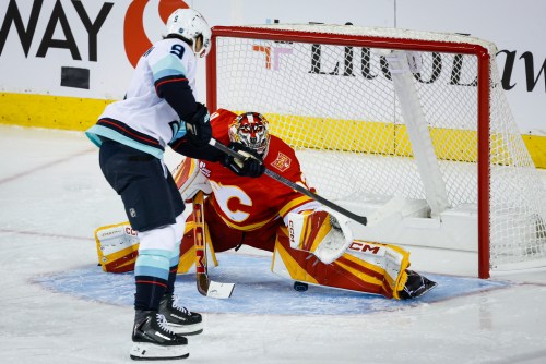 Seattle Kraken's Chandler Stephenson, left, scores on Calgary Flames goalie Dustin Wolf during third period NHL hockey action in Calgary on Thursday, Oct. 1, 2026.THE CANADIAN PRESS/Jeff McIntosh