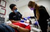 Dr. Melvin Lee, left, performs a tooth extraction for patient Robert McFarlane, who is eligible for the Canadian Dental Care Plan, as team member Sofia Christow-Filleul assists at his dental clinic in Ottawa, on Wednesday, Aug. 7, 2024. THE CANADIAN PRESS/Justin Tang