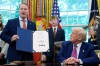 FILE - President Donald Trump listens as Sen. Jon Husted, R-Ohio, speaks while holding up a signed resolution in the Oval Office of the White House, May 9, 2025, in Washington. (AP Photo/Alex Brandon, File)
