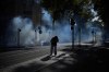 A student runs out the teargas during a protest against under-resourced schools in Lyon, France, Friday, Oct. 2, 2026. (AP Photo/Laurent Cipriani)