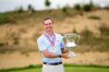 In this photo provided by USGA , Andrew Bailey holds the Robert T. Jones Jr. Memorial Trophy after winning the championship at the 2026 U.S. Mid-Amateur at Sand Valley Resort (The Lido) in Nekoosa, Wis. on Thursday, Oct. 1, 2026. (Logan Whitton/USGA via AP).