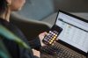 A person uses the calculator app on their phone and works on a spreadsheet in a photo illustration made in Toronto, on Monday, Sept. 22, 2025. THE CANADIAN PRESS/Sammy Kogan