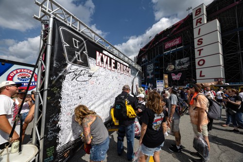 Fans signs their name to a tribute sign to the late Kyle Busch before a NASCAR Cup Series auto race Saturday, Sept. 19, 2026, in Bristol, Tenn. (AP Photo/Wade Payne)