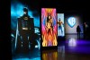 FILE - A visitor walks past portraits of DC Comics superheroes as she enters the 