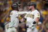 San Diego Padres' Jake Cronenworth, right, is congratulated by teammate Jackson Merrill (3) after hitting a solo home run during the fifth inning in Game 3 of baseball's National League Division Series against the Milwaukee Brewers Tuesday, Oct. 6, 2026, in San Diego. (AP Photo/Gregory Bull)