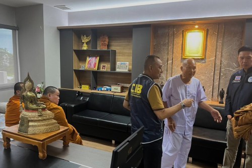 FILE -In this photo released by the Central Investigation Bureau, Alongkot Poonmook, formerly known as Phra Ratcha Wisutthiprachanat, second right in white, talks to police personnel at the Central Investigation Bureau in Bangkok, Thailand, Aug. 26, 2025. (Central Investigation Bureau via AP, File)