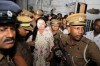 Prison officers escort Shiranthi Rajapaksa, the wife of Sri Lanka's former President Mahinda Rajapaksa, to a prison vehicle outside a magistrate's court in Colombo, Sri Lanka, Wednesday, Oct. 7, 2026. (AP Photo/Lahiru Harshana)