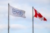 A Stelco flag flies beside a Canadian flag at the steel production facility in Hamilton, Ont., on Monday, February 10, 2025. THE CANADIAN PRESS/Nick Iwanyshyn