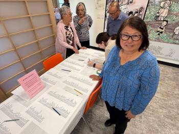 MORGAN MODJESKI / FREE PRESS 
Sandra Shibata, vice-president with the Japanese Cultural Association of Manitoba, on Saturday stands next to a table displaying the names of people who were expelled to Manitoba after they were forcefully removed from the west coast in 1941. In the other room, the association was hosting a watch party for the unveiling of the Japanese Canadian Monument in Victoria B.C. one of 15 taking place across the country.