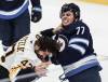 Winnipeg Jet Tyrel Bauer (77) and Boston Bruin Mark Kastelic (47) fight during the first period in Winnipeg on Friday.