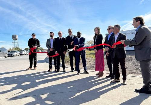 MATTHEW FRANK / FREE PRESS
                                Prof. Ibrahima Diallo cuts the ribbon Monday to unveil the names of two completed streets running through the Water Tower District in St. Boniface, one of which will bear his name.