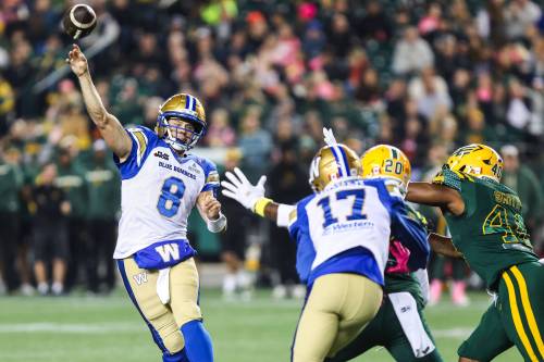 CODIE McLACHLAN / THE CANADIAN PRESS
                                Winnipeg Blue Bombers quarterback Zach Collaros (8) throws a pass under pressure from Edmonton Elks&rsquo; Kenny Logan Jr. (20) and Robbie Smith (40) during first half action in Edmonton on Friday.