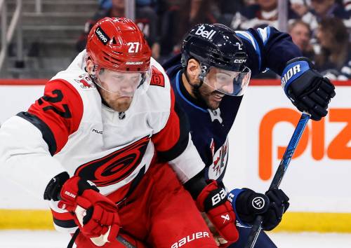 JOHN WOODS / THE CANADIAN PRESS
Winnipeg Jets' Dylan DeMelo (2) defends against Carolina Hurricanes' Nikolaj Ehlers (27) during the first period in Winnipeg on Saturday.
