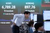 Traders watch monitors near a screen showing the Korea Composite Stock Price Index (KOSPI) at the foreign exchange dealing room of the Hana Bank headquarters in Seoul, Thursday, Oct. 8, 2026. (AP Photo/Ahn Young-joon)