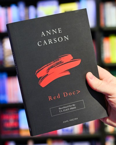 After the announcement of the Canadian writer Anne Carson as the winner of the 2026 Nobel Prize in Literature, a man's hand holds her book 