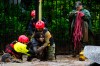 A man is pulled to safety by rescue workers after heavy rains caused flash flooding in the Las Condes district of Santiago, Chile, Thursday, Oct. 8, 2026. (AP Photo/Esteban Felix)