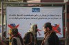 FILE - A Taliban policeman, center, and two other men walk past a poster stating that cameras, phones, and weapons are banned inside a stadium where a public execution was taking place in the city of Khost, eastern Afghanistan, Dec. 2, 2025. (AP Photo/Saifullah Zahir, File)