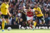 Arsenal's Bruno Guimaraes, centre, challenges for the ball with Leeds' James Justin, right, during the English Premier League soccer match between Arsenal and Leeds United in London, Saturday, Oct. 10, 2026. (AP Photo/Alastair Grant)