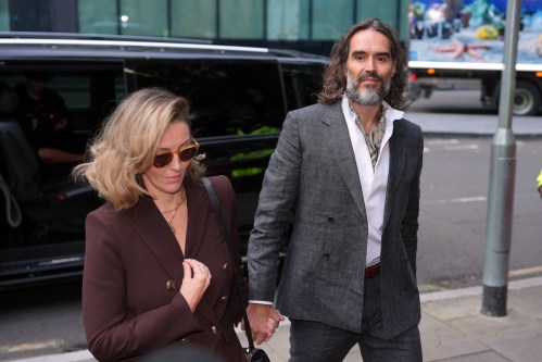 Comedian and actor Russell Brand, accompanied by his wife Laura Brand, arrives at Southwark Crown Court where he is charged with counts of rape and sexual assault against six women, which he has denied, in London, Monday, Oct. 12, 2026.(AP Photo/Kin Cheung)
