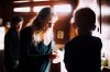 This image released by A24 shows filmmaker Nathan Fielder, left, and Elizabeth Holmes, center, in a scene from 