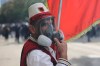 A protester wears a traditional costume and a tear gas mask during clashes as students joined an anti-government demonstration in Tirana, Albania, Thursday, Oct. 15, 2026. (AP Photo/Hameraldi Agolli)