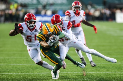 Edmonton Elks' Zach Mathis (centre) scores a touchdown under pressure from Calgary Stampeders' Kelechi Anyalebechi (51) and BoPete Keyes (35) during second half CFL football action in Edmonton on Saturday, Sept. 12, 2026. THE CANADIAN PRESS/Codie McLachlan