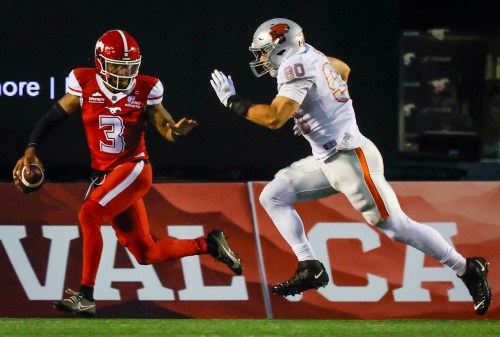 B.C. Lions' Mathieu Betts, right, chases down Calgary Stampeders quarterback Vernon Adams Jr. during second half CFL football action in Calgary, Thursday, Aug. 13, 2026. THE CANADIAN PRESS/Jeff McIntosh