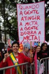 A supporter holds a sign with a message reading in Portuguese, 
