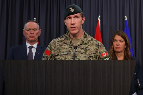 Major-General L.W. Rutland, centre, speaks as National Defence Minister David McGuinty, left, and Alberta Premier Danielle Smith, right, listen during a press conference in Edmonton, Sunday, Oct. 18, 2026. THE CANADIAN PRESS/James Maclennan