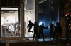 Youths break a store window during clashes between protestors and police in Paris, Sunday, Oct. 18, 2026. (AP Photo/Emma Da Silva)