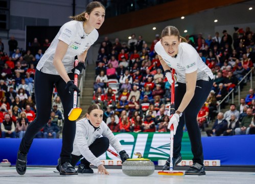 Switzerland's skip Xenia Schwaller, centre, delivers a stone against Team Canada as lead Selina Rychiger, left, and third Selina Gafner sweep during the final at the world women’s curling championship in Calgary on March 22, 2026.  THE CANADIAN PRESS/Jeff McIntosh