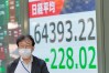 A person walks in front of an electronic stock board showing Japan's Nikkei index at a securities firm Thursday, Oct. 22, 2026, in Tokyo. (AP Photo/Eugene Hoshiko)