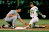 FILE - Oakland Athletics' Jose Canseco is almost off picked off by Boston Red Sox first baseman Todd Benzinger during the first inning of a baseball game, Monday, Aug. 29, 1988, in Oakland, Calif. (AP Photo/Paul Sakuma, File)