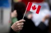 A person waves a small Canadian flag during a protest against U.S. President Donald Trump's tariffs in Vancouver, B.C., on Tuesday, March 4, 2025. THE CANADIAN PRESS/Ethan Cairns