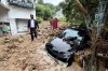 In this image from a video released by Phuket province's Public Relations Department, an official walks at the site of a mudslide after flash flooding in Phuket, Thailand, Monday, Oct. 26, 2026. (Phuket province's Public Relations Department via AP)