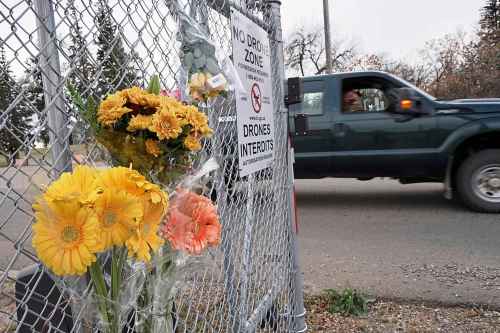 Flowers are placed at the entrance to Canadian Forces Base Wainwright in Alberta, Canada, Monday, Oct. 19, 2026. (AP Photo/Ty O'Neil)