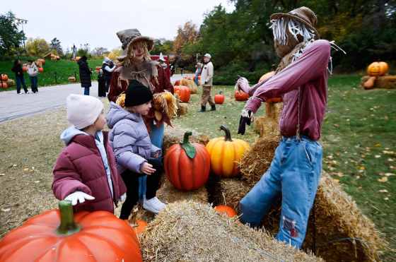 Patch the Scarecrow has fun with Kalina (left) and Kasia at Boo at the Zoo at Assiniboine Park Zoo on Sunday. (John Woods / Free Press)
